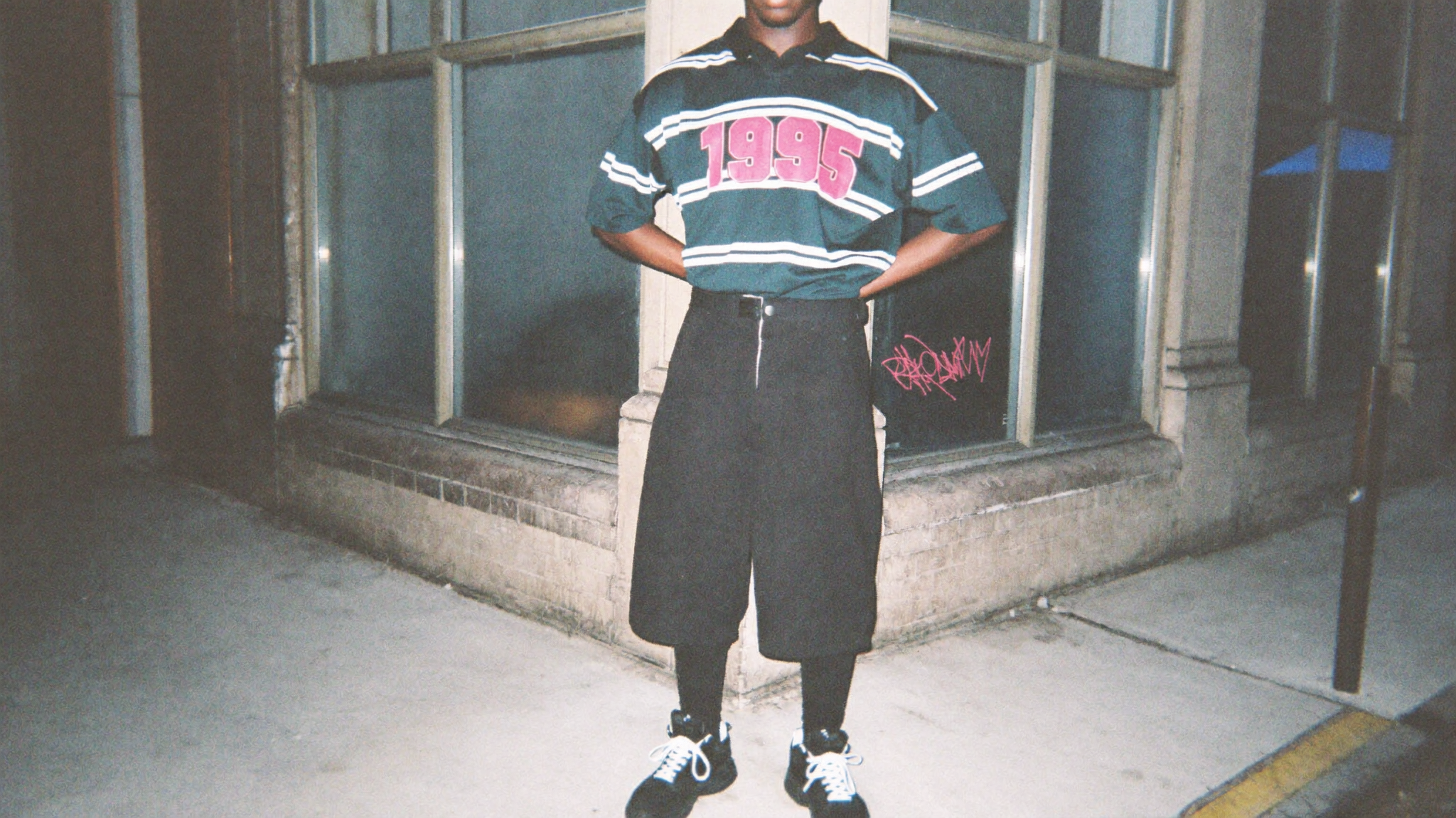 Medium shot of a young black man in his 20s, standing stiffl